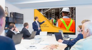 Businessman gesturing to Presentation Video Wall in a corporate meeting room